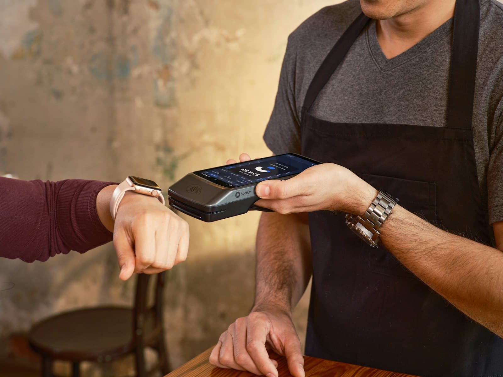 A shopkeeper holding out a card terminal for a contactless payment